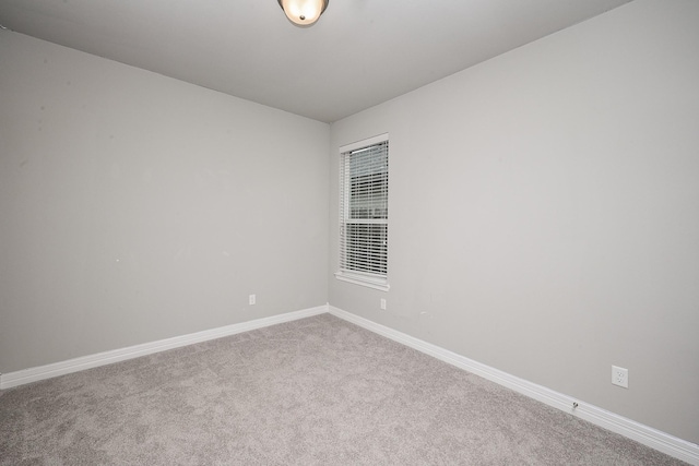 carpeted spare room featuring baseboards