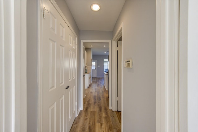 hall with baseboards, light wood-type flooring, and recessed lighting