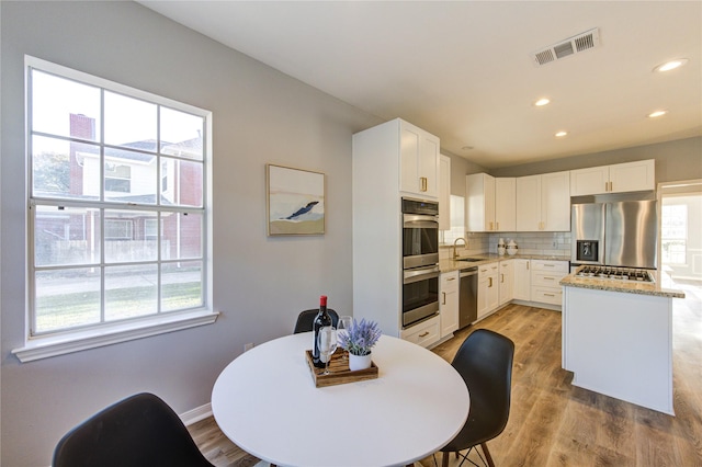 dining room with recessed lighting, baseboards, visible vents, and light wood finished floors