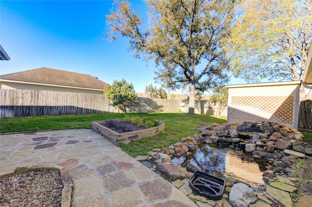 view of yard featuring a vegetable garden, a fenced backyard, and a patio