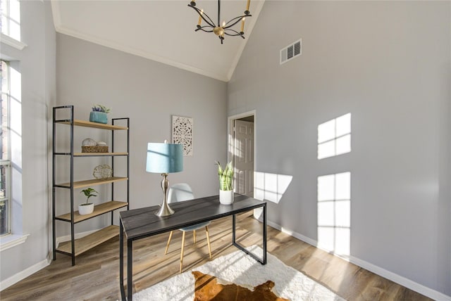 home office featuring high vaulted ceiling, visible vents, an inviting chandelier, and wood finished floors