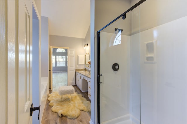 full bath with lofted ceiling, a tub to relax in, a stall shower, and vanity