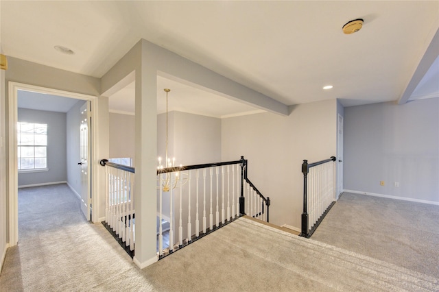 corridor with an inviting chandelier, carpet, an upstairs landing, and baseboards