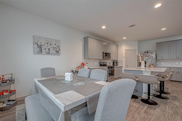 dining area with visible vents, light wood-style flooring, and recessed lighting