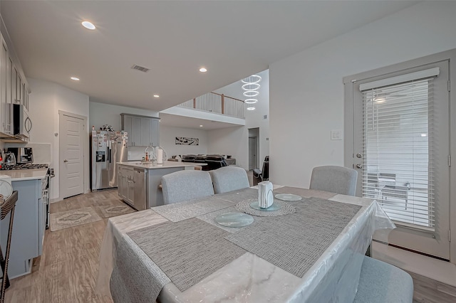 dining area with light wood finished floors, visible vents, and recessed lighting