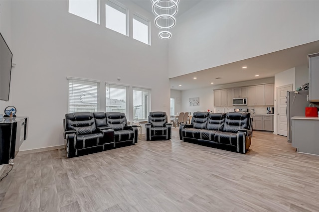 living room with baseboards, recessed lighting, and light wood-style floors