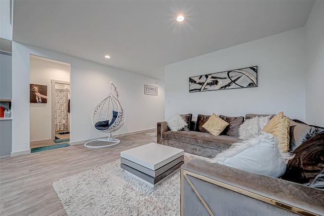 living room with baseboards, wood finished floors, and recessed lighting