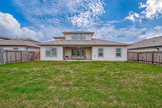 rear view of house with a patio area, a lawn, and a fenced backyard