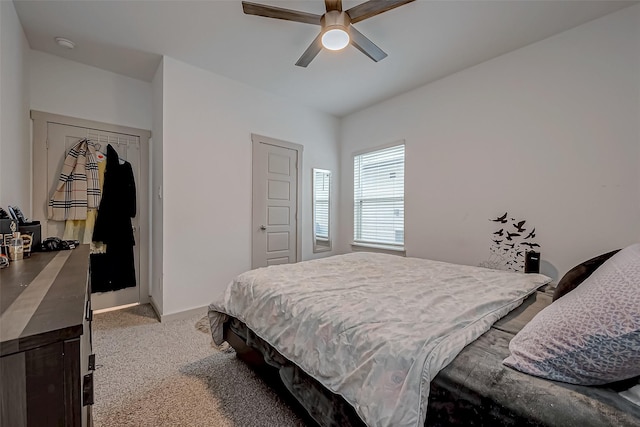 bedroom featuring baseboards, ceiling fan, and light colored carpet