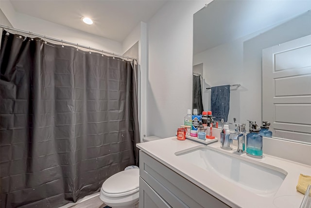 full bathroom featuring a shower with shower curtain, vanity, and toilet