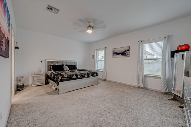 carpeted bedroom with baseboards, visible vents, and ceiling fan