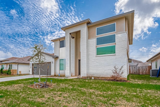 view of front of home featuring driveway, stucco siding, an attached garage, fence, and a front yard