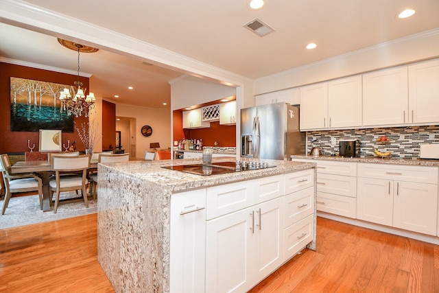 kitchen with visible vents, stainless steel fridge with ice dispenser, decorative backsplash, light wood-style floors, and black electric stovetop