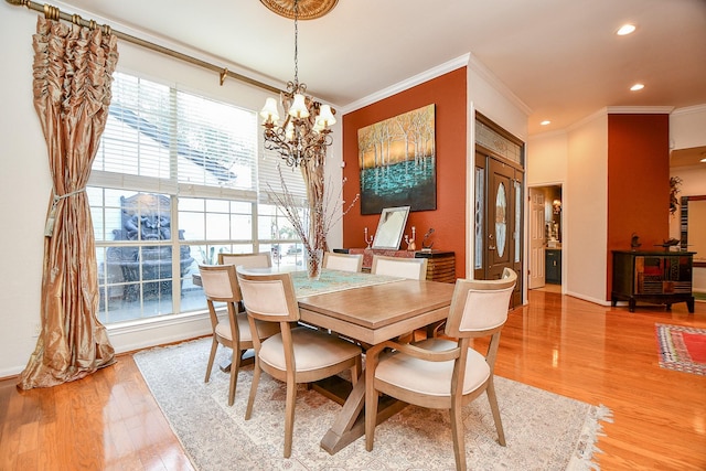 dining space with light wood-style flooring, ornamental molding, recessed lighting, an inviting chandelier, and baseboards