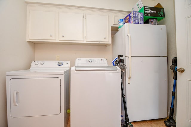 washroom featuring cabinet space and independent washer and dryer