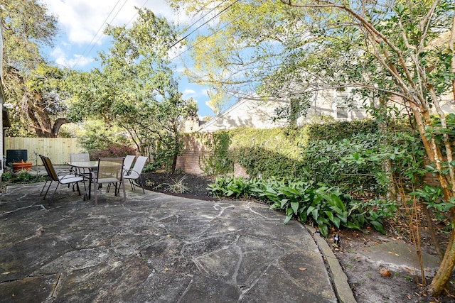 view of patio with outdoor dining area, central AC unit, and a fenced backyard