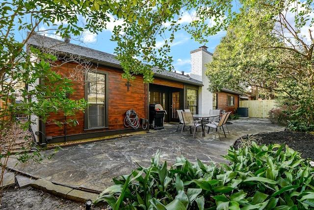 rear view of property with a patio, central AC unit, a chimney, and fence