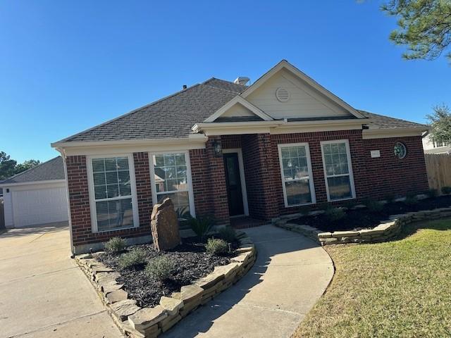 view of front of property featuring a garage, brick siding, and a front lawn