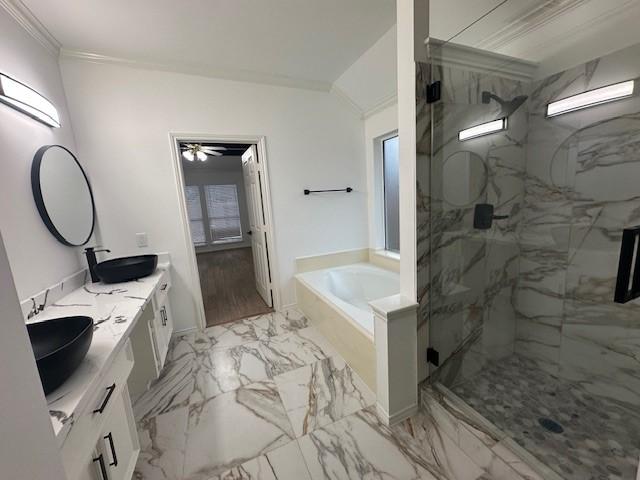 full bathroom featuring marble finish floor, a garden tub, a marble finish shower, ornamental molding, and a sink