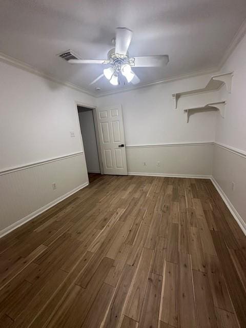 interior space with ornamental molding, wood finished floors, visible vents, and a ceiling fan