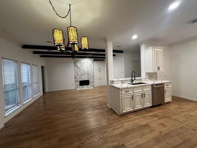 kitchen with a premium fireplace, open floor plan, a sink, wood finished floors, and dishwasher