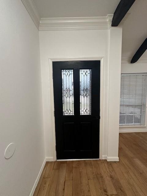 entrance foyer featuring beam ceiling, crown molding, baseboards, and wood finished floors