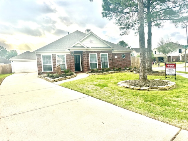 view of front of house featuring a garage, a front yard, brick siding, and fence