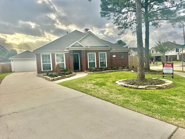 view of front of house with a front yard, fence, an outdoor structure, and brick siding