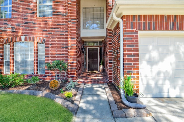 doorway to property featuring brick siding and an attached garage