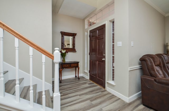 entryway with stairway, baseboards, and wood finished floors