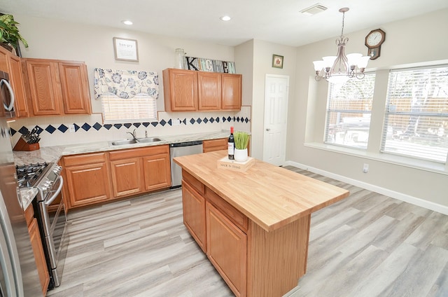 kitchen featuring tasteful backsplash, visible vents, appliances with stainless steel finishes, a sink, and wood counters