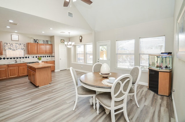 dining room with baseboards, visible vents, light wood-type flooring, high vaulted ceiling, and recessed lighting