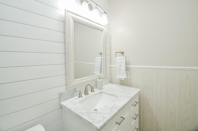 bathroom with a wainscoted wall and vanity