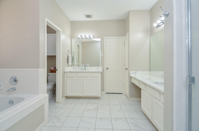 full bathroom with two vanities, visible vents, toilet, and a bath