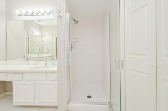 bathroom with a stall shower, tile patterned flooring, and vanity