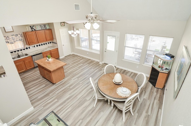 dining space with baseboards, visible vents, and light wood finished floors