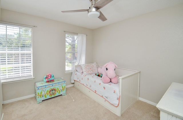 carpeted bedroom with a ceiling fan and baseboards