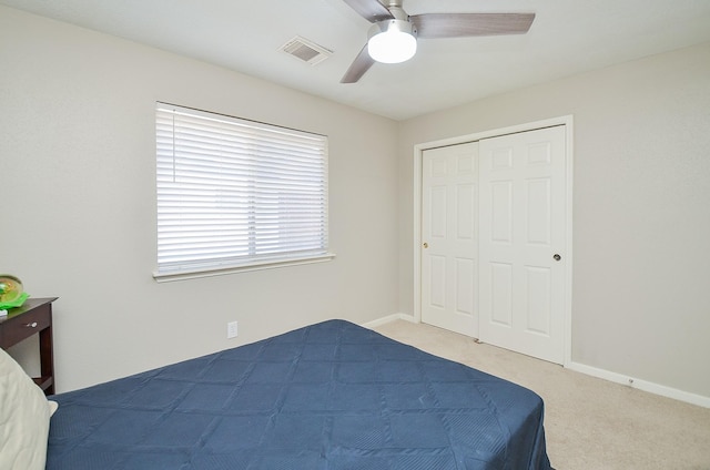 carpeted bedroom featuring ceiling fan, a closet, visible vents, and baseboards