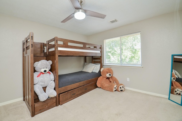 carpeted bedroom with baseboards, visible vents, and a ceiling fan