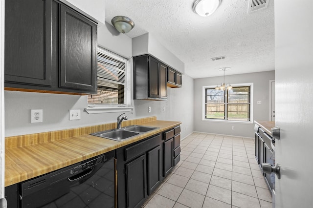 kitchen featuring black dishwasher, visible vents, a sink, and light tile patterned flooring