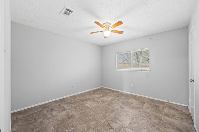 spare room with ceiling fan, a textured ceiling, visible vents, and baseboards