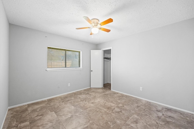 unfurnished bedroom featuring ceiling fan, a closet, baseboards, and a textured ceiling