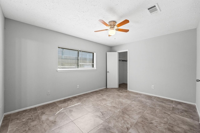 unfurnished bedroom featuring baseboards, visible vents, a ceiling fan, a textured ceiling, and a closet