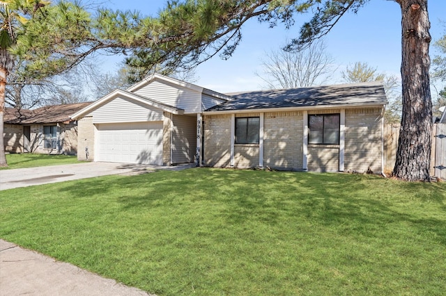 view of front facade featuring a garage, brick siding, driveway, and a front yard