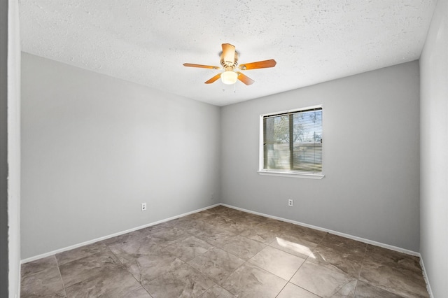 spare room featuring a textured ceiling, baseboards, and a ceiling fan