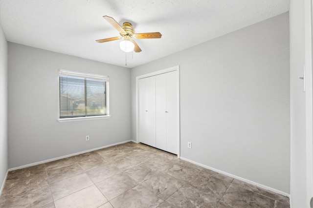 unfurnished bedroom featuring a ceiling fan, a closet, and baseboards