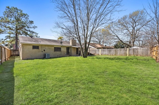 view of yard with a fenced backyard and central AC unit