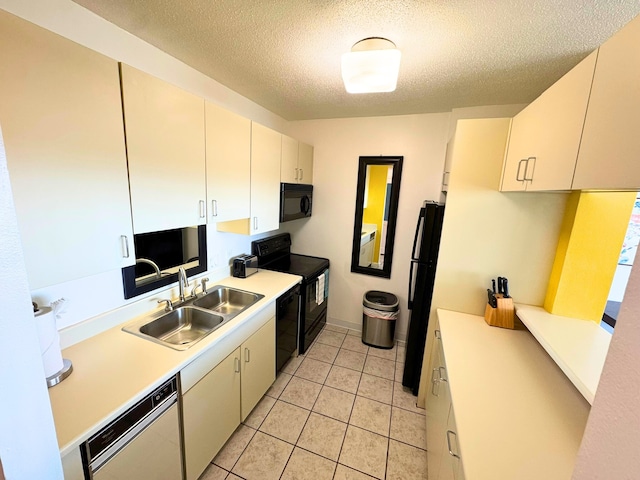 kitchen featuring light countertops, a textured ceiling, black appliances, a sink, and light tile patterned flooring