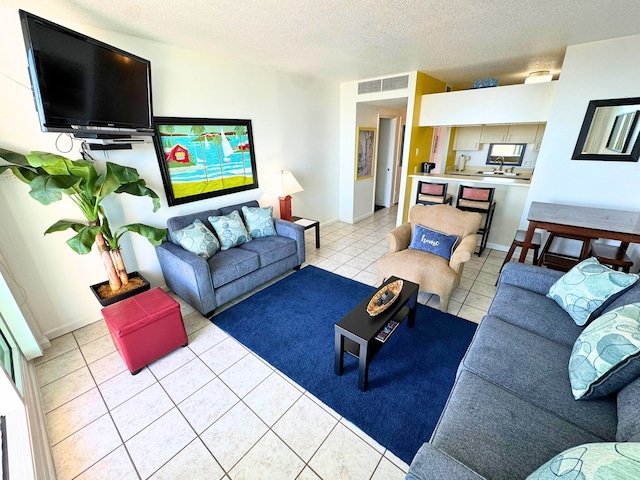 living area with visible vents, a textured ceiling, and light tile patterned flooring