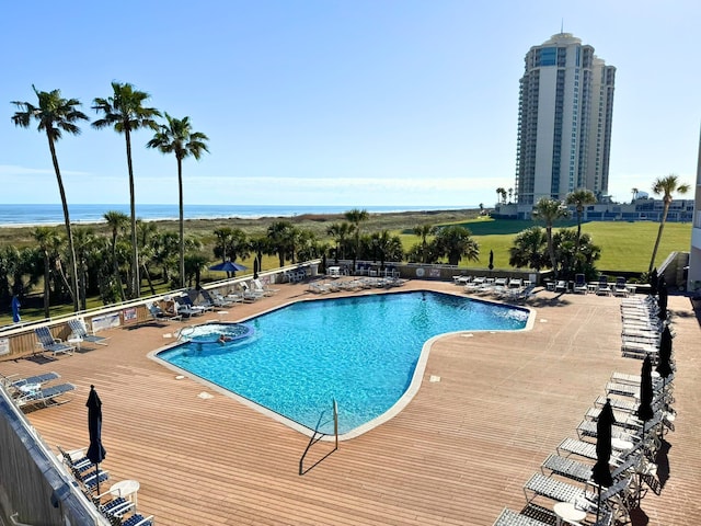 view of pool with a patio, fence, and a pool with connected hot tub